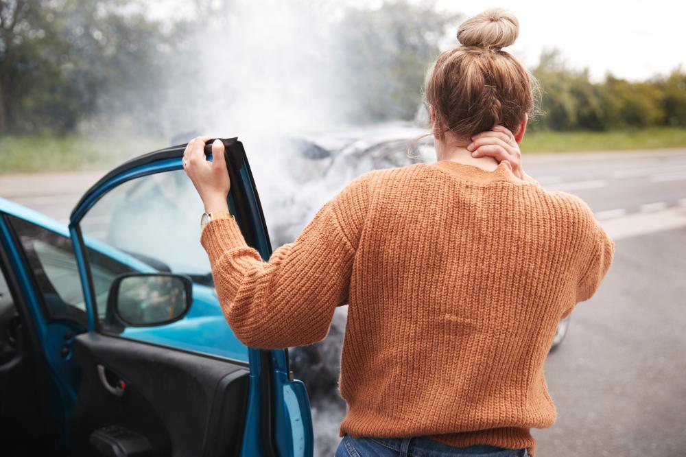 Click to enlarge A woman is looking at the scene of a car crash, knowing she will be eligible for a typi ...
