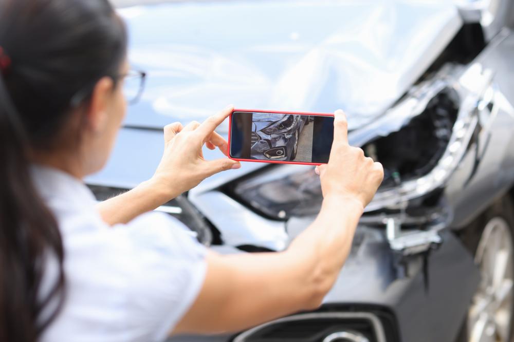 Click to enlarge Woman taking photo of vehicle after car accident